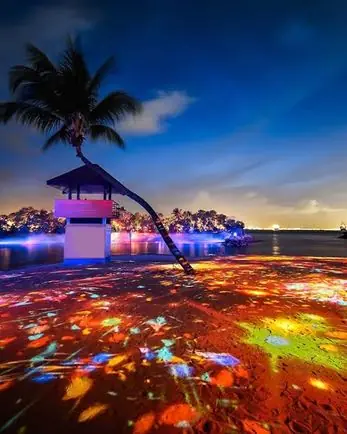 Light installation glowing on a Sentosa beach at dusk