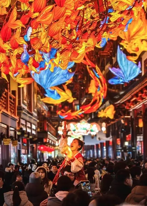 A performer above the crowd beneath giant colourful lanterns