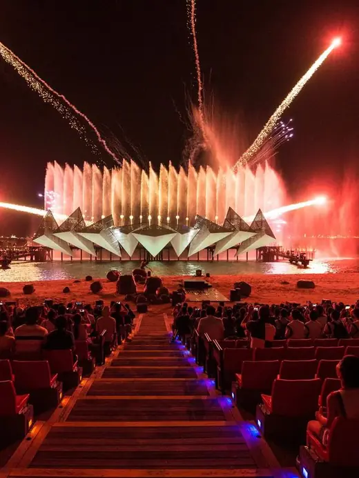 Fountain and firework show over a crowd
